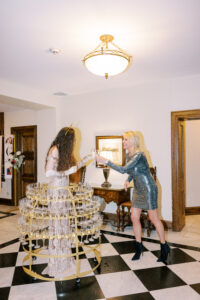 BVTLive! Champagne skirt greeter welcomes guest in entryway with a complimentary flute of champagne as she enters the party