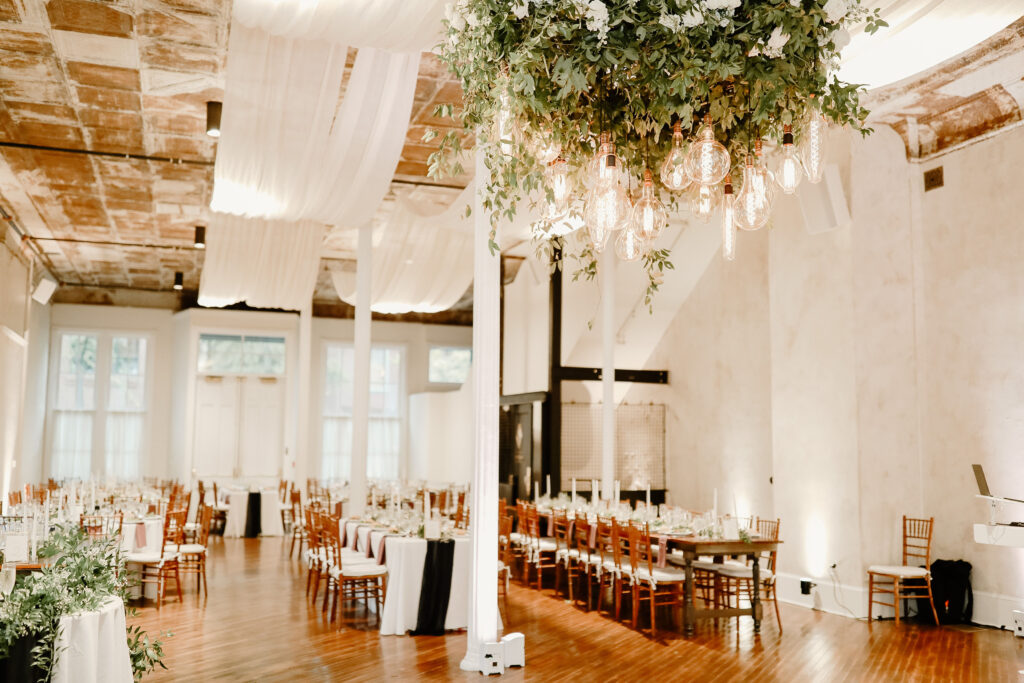 Reception hall decorated with white drapery and green plants