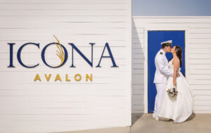 bride and groom kissing in front of sign that reads ICONA Avalon
