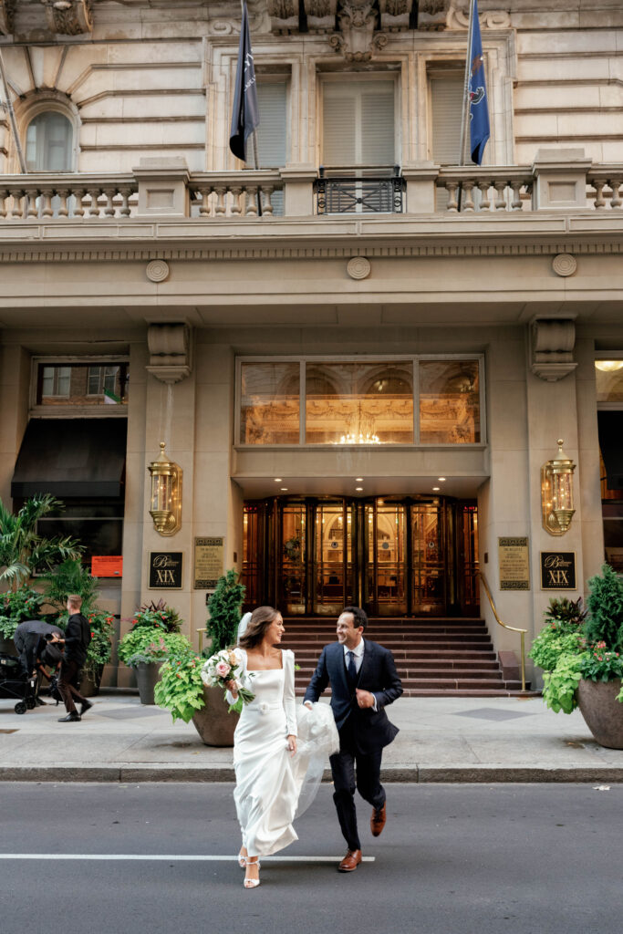 bride and groom running out of the hotel in wedding dress and tux while looking at each other