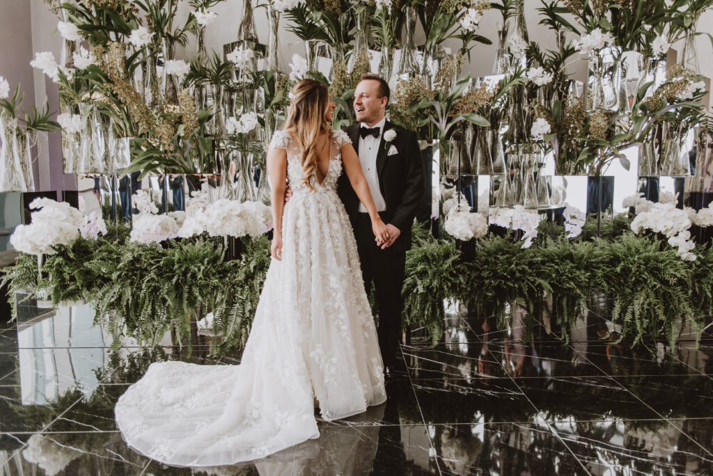 Bride and groom standing in front of botanical display at the Four Seasons Hotel
