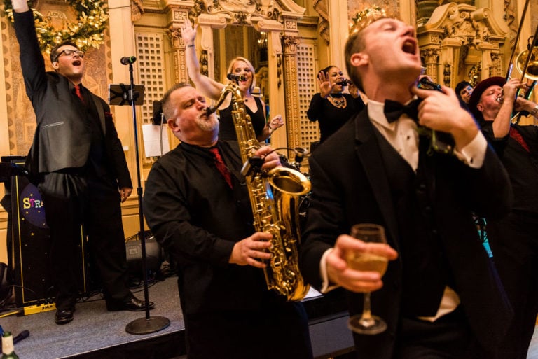 Saxophone player passionately playing at wedding with guest